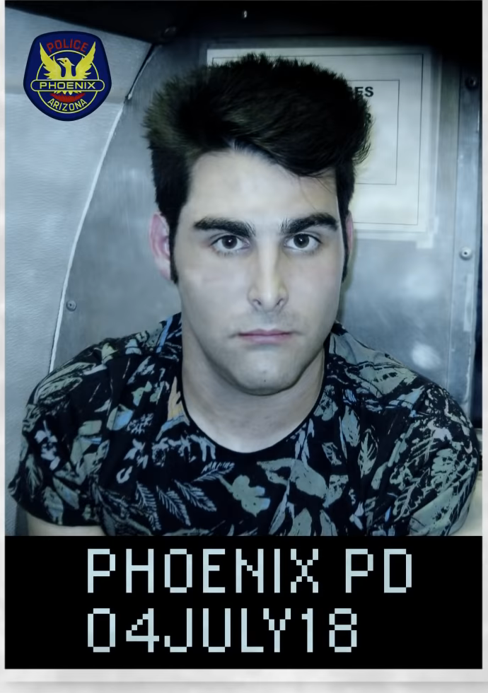 Booking photo graphic from a 2022 broadcast ad, labeled Phoenix PD, July 4, 2018. He was charged on five counts; all five were dismissed and he was not convicted.